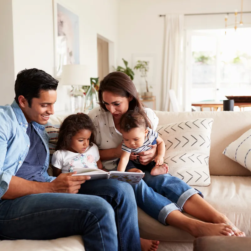 A family reading together on the sofa in a comfortable, evenly heated room