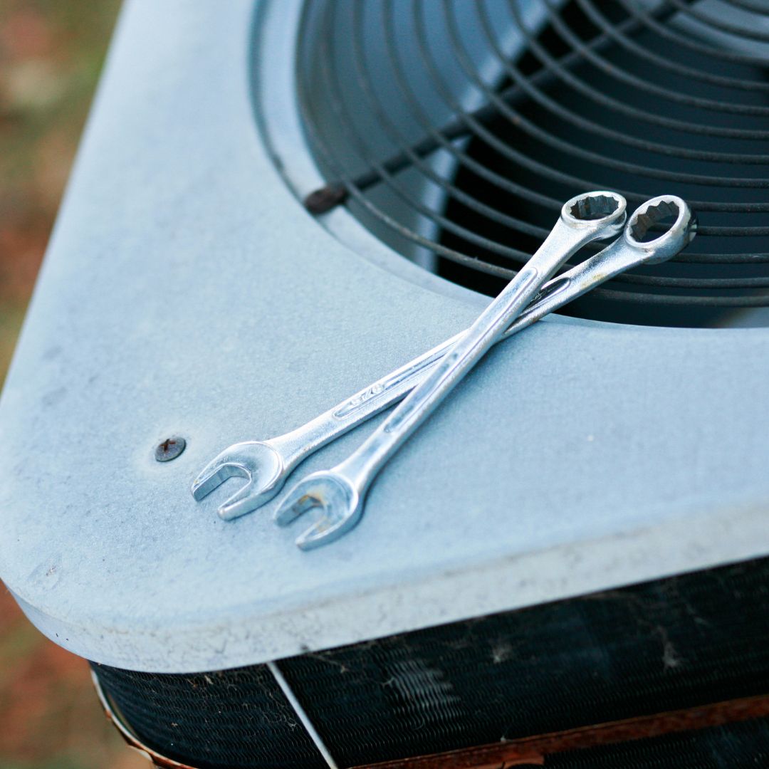 An image of two wrenches on an AC unit.