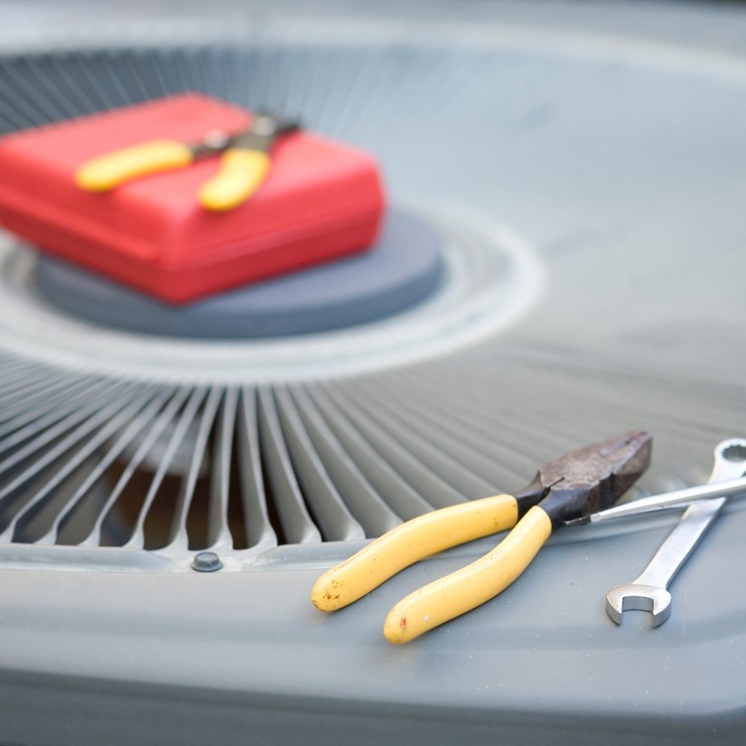 man repairing an AC unit