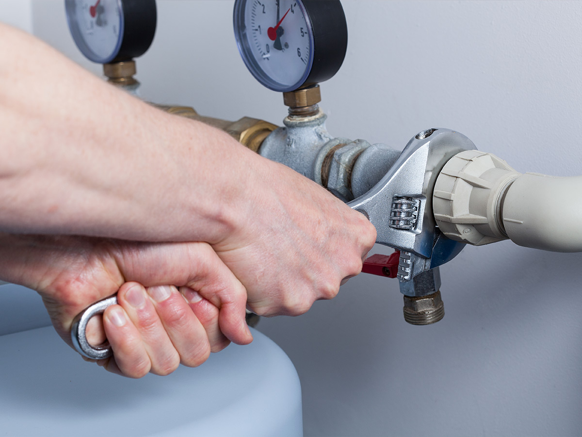 Image of a plumber working on pipes. 