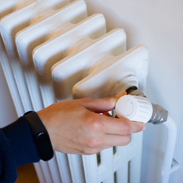 a person adjusting the temperature of a heater